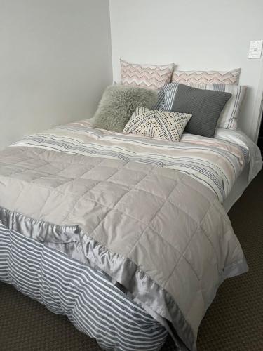1 cama con almohadas en el dormitorio en TAURANGA, Bay of Plenty, en Tauranga