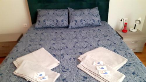 a bedroom with a blue bed with towels on it at Immaculate 2-Bed Apartment in Glyka Nera