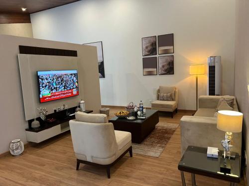 a living room with a couch and a tv at Marco Polo Resort Kaghan in Kāgān