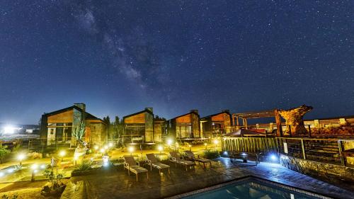 a resort with a swimming pool at night at Sirius Valle in Valle de Guadalupe