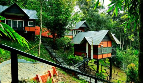 a group of small houses in a forest at Santhi Hill View Resort in Munnar