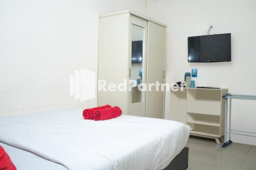 Tempat tidur dalam kamar di Jabrix Hotel Mitra RedDoorz