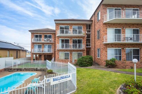 an apartment building with a pool and a yard at Views on Ballingalla in Narooma