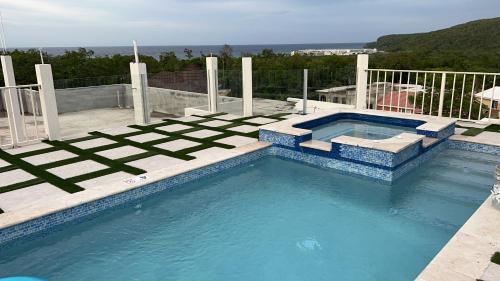 een groot zwembad met blauwe tegels bij Joy Estate Rooftop Pool n View unit #1 in Falmouth