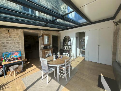 - un salon décloisonné avec une table et des chaises dans l'établissement Le 33 Maison de charme coeur Cotentin, à Valognes