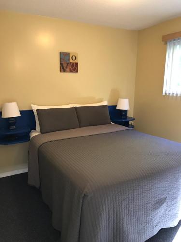 a bedroom with a large bed with two lamps at Kokanee Glacier Resort in Nelson