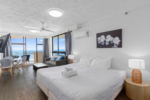 ein Schlafzimmer mit einem Bett mit einem ausgestopften Tier darauf in der Unterkunft Beachcomber Resort - Deluxe Rooms in Gold Coast