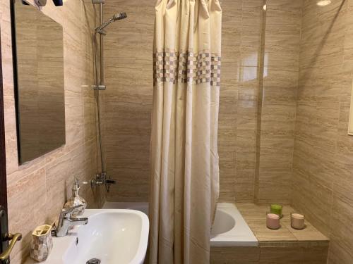 a bathroom with a shower curtain and a sink at Modern downtown Sheikh Zayed Condo in Sheikh Zayed