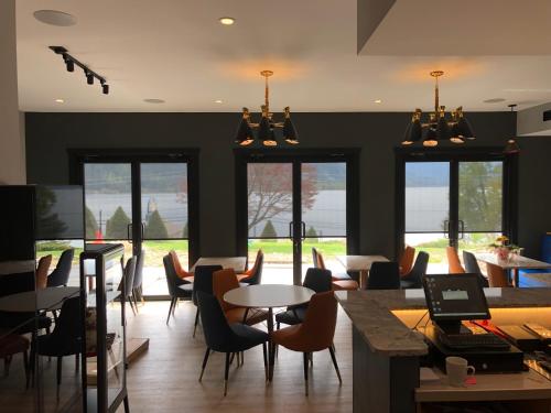 a dining room with tables and chairs and windows at Kokanee Glacier Resort in Nelson