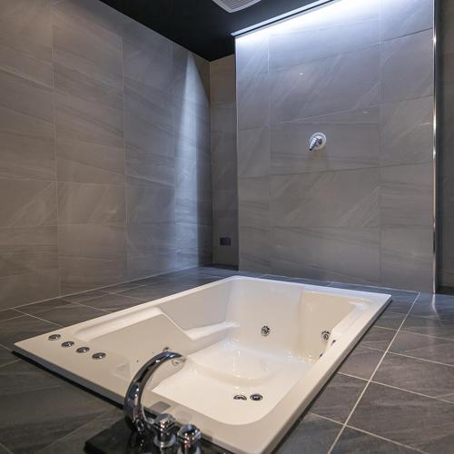 a bathroom with a bath tub with a shower at Soho Motel in Taoyuan