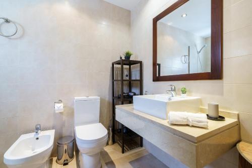 bagno con lavandino, servizi igienici e specchio di Fantastico Atico Duplex en Marbella a Marbella