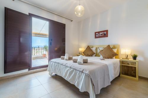 マルベーリャにあるFantastico Atico Duplex en Marbellaのベッドルーム(大型ベッド1台、大きな窓付)