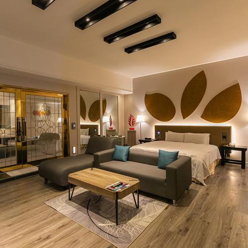 a bedroom with a bed and a couch and a table at Soho Motel in Taoyuan