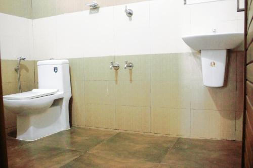 een badkamer met een toilet en een wastafel bij Pauls Retreat Wayanad in Wayanad