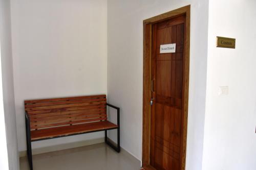 a wooden bench sitting next to a door at Pauls Retreat Wayanad in Wayanad