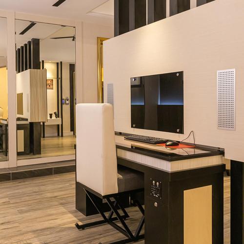 a computer desk with a keyboard and a computer monitor at Soho Motel in Taoyuan