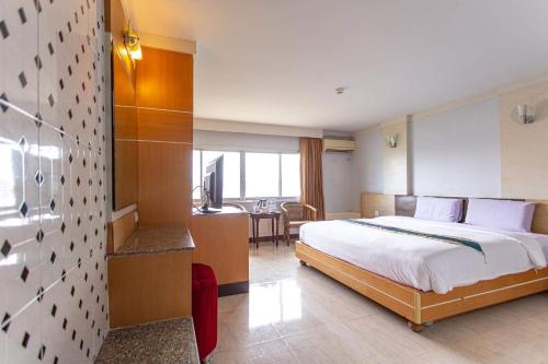 a hotel room with a bed and a desk at Satit Grand View Hotel in Sadao
