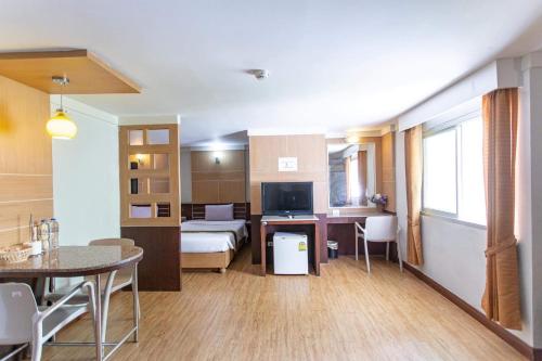 a living room with a bed and a dining room at Satit Grand View Hotel in Sadao