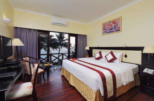 a hotel room with a large bed and a large window at Saigon Phu Quoc Resort & Spa in Phú Quốc