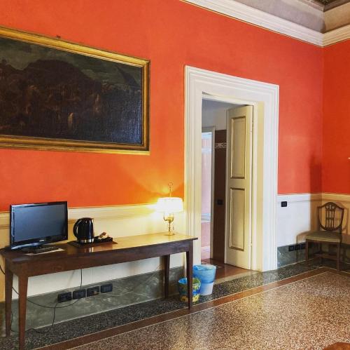 a room with a desk and a painting on the wall at Palazzo Tucci Residenza d'epoca in Lucca