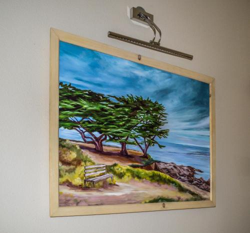 a painting of a painting of a bench on a wall at Rio Vista Inn & Suites Santa Cruz in Santa Cruz