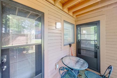 a small porch with a table and chairs and a window at Outer Limits in Killington