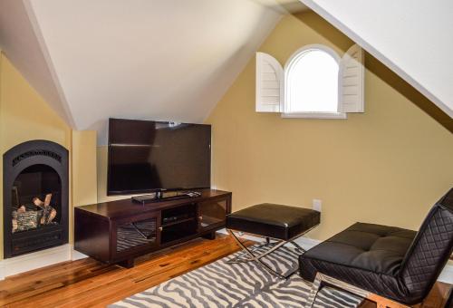 uma sala de estar com televisão e lareira em Rio Vista Inn & Suites Santa Cruz em Santa Cruz
