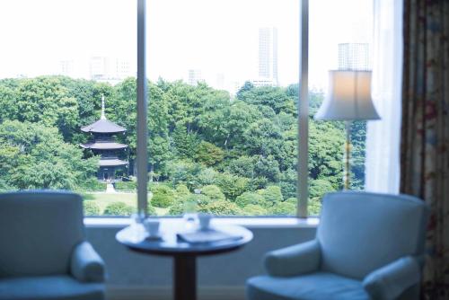 a room with two chairs and a table and a window at Hotel Chinzanso Tokyo in Tokyo