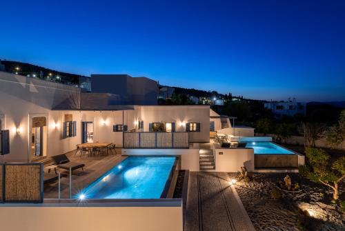 a villa with a swimming pool at night at Kalathos Square luxury suites in Kalathos
