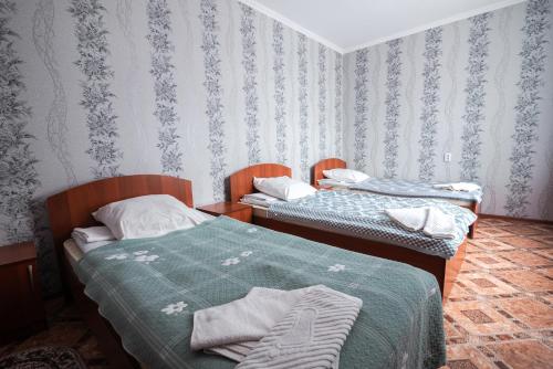 two beds in a room with blue and white wallpaper at Гостиница Караганда in Karagandy