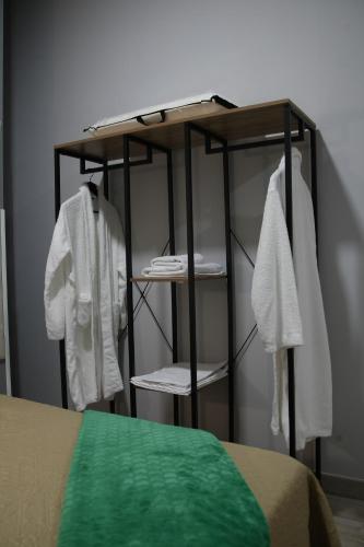 a room with a shelf with white robes and towels at Apartamentos Las trece llaves Jacuzzi bajo reserva in Merida