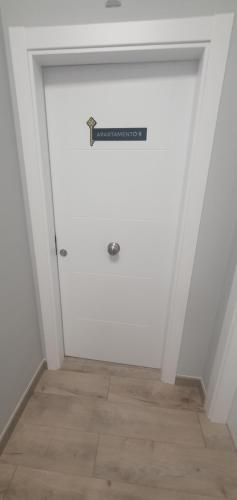 a white door with a sign on top of it at Apartamentos Las trece llaves Jacuzzi bajo reserva in Merida