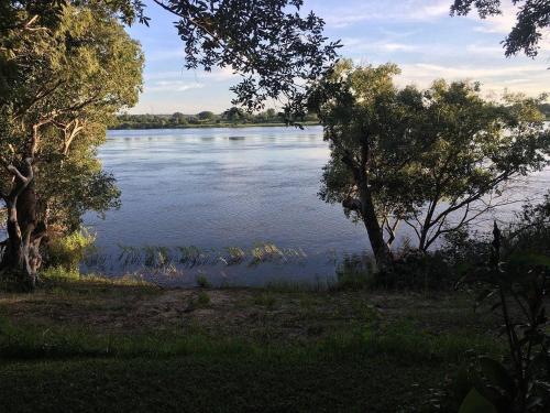 a view of a lake with trees in the foreground at Caprivi River Lodge in Katima Mulilo