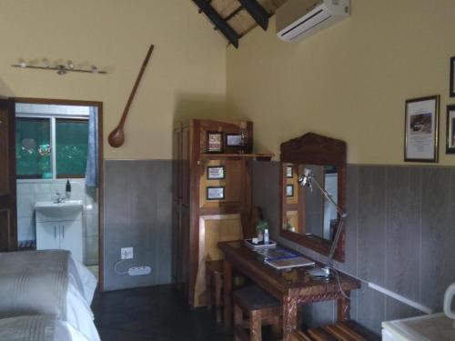 a bedroom with a desk and a mirror and a bed at Caprivi River Lodge in Katima Mulilo