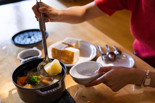 a person is stirring a pot of food with a spoon at Kawaguchiko Country Cottage Ban - Glamping Resort - in Fujikawaguchiko