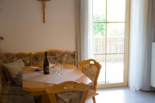 a dining room table with a bottle of wine on it at Ferienwohnungen Seebauer in Nittenau