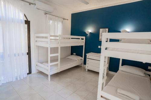a room with three bunk beds and a blue wall at Villa Aya - 2 Bedroom with Shared Pool in Il-Pergla