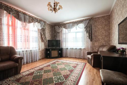 a living room with a couch and a tv and curtains at Гостиница Караганда in Karagandy