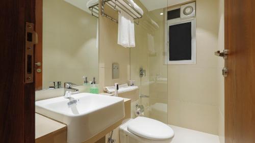 a bathroom with a sink and a toilet and a shower at AR Suites Jewels Royale - Koregaon Park NX in Pune