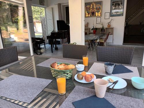 a table with a bowl of fruit and orange juice at Chalet banane devant piscine, a 6km du festival de piano de la roque d'anthéron in Rognes