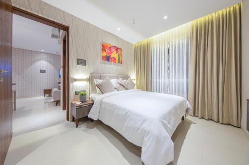 a bedroom with a white bed and a large window at AR Suites Jewels Royale - Koregaon Park NX in Pune