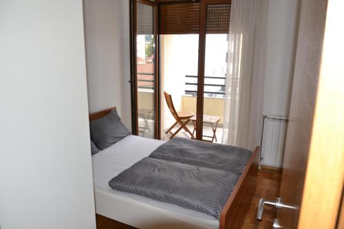 a bedroom with a bed and a view of a balcony at Apartment Lazarus Banja Luka in Banja Luka