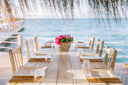 a long wooden table with chairs and a fountain at Ilica Hotel Spa & Wellness Resort in Çeşme