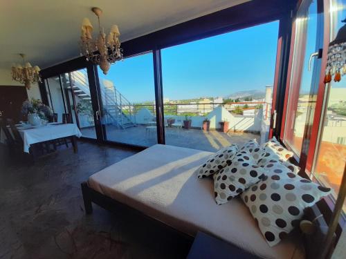 a bedroom with a bed with pillows and a large window at Royal stylish view apartment in Koropíon