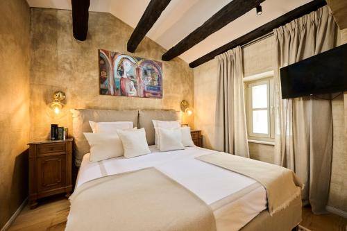 a bedroom with a large bed with white sheets and pillows at Casa Ars Natura II in Grožnjan