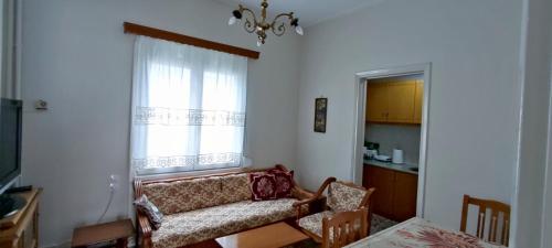 - un salon avec un canapé et une fenêtre dans l'établissement Σπίτι στην πόλη Άρτα κοντά στην λίμνη, à Árta