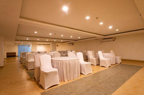 a banquet hall with white tables and chairs at Zone Connect by The Park Parra Goa in Anjuna