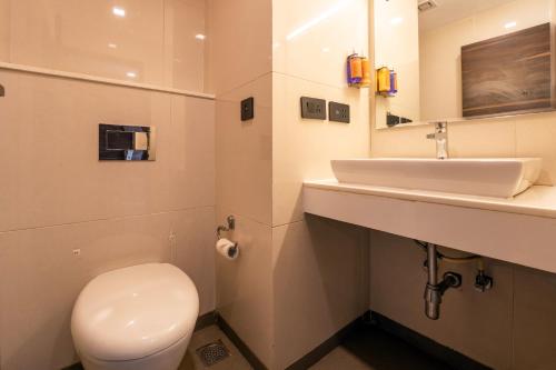 a bathroom with a white toilet and a sink at Zone Connect by The Park Parra Goa in Anjuna