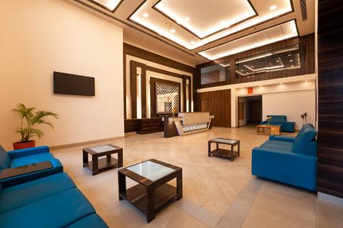 a living room with blue couches and a table at Zone Connect by The Park Parra Goa in Anjuna