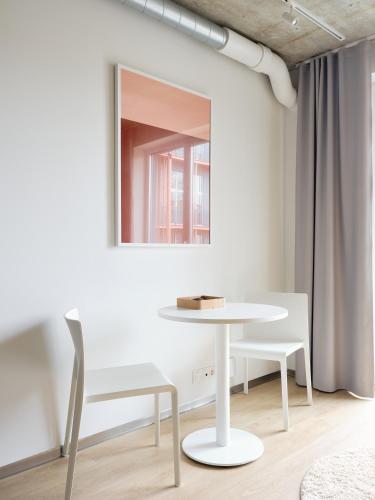 a table and chairs in a room with a mirror at Campus House by Larsen in Tallinn